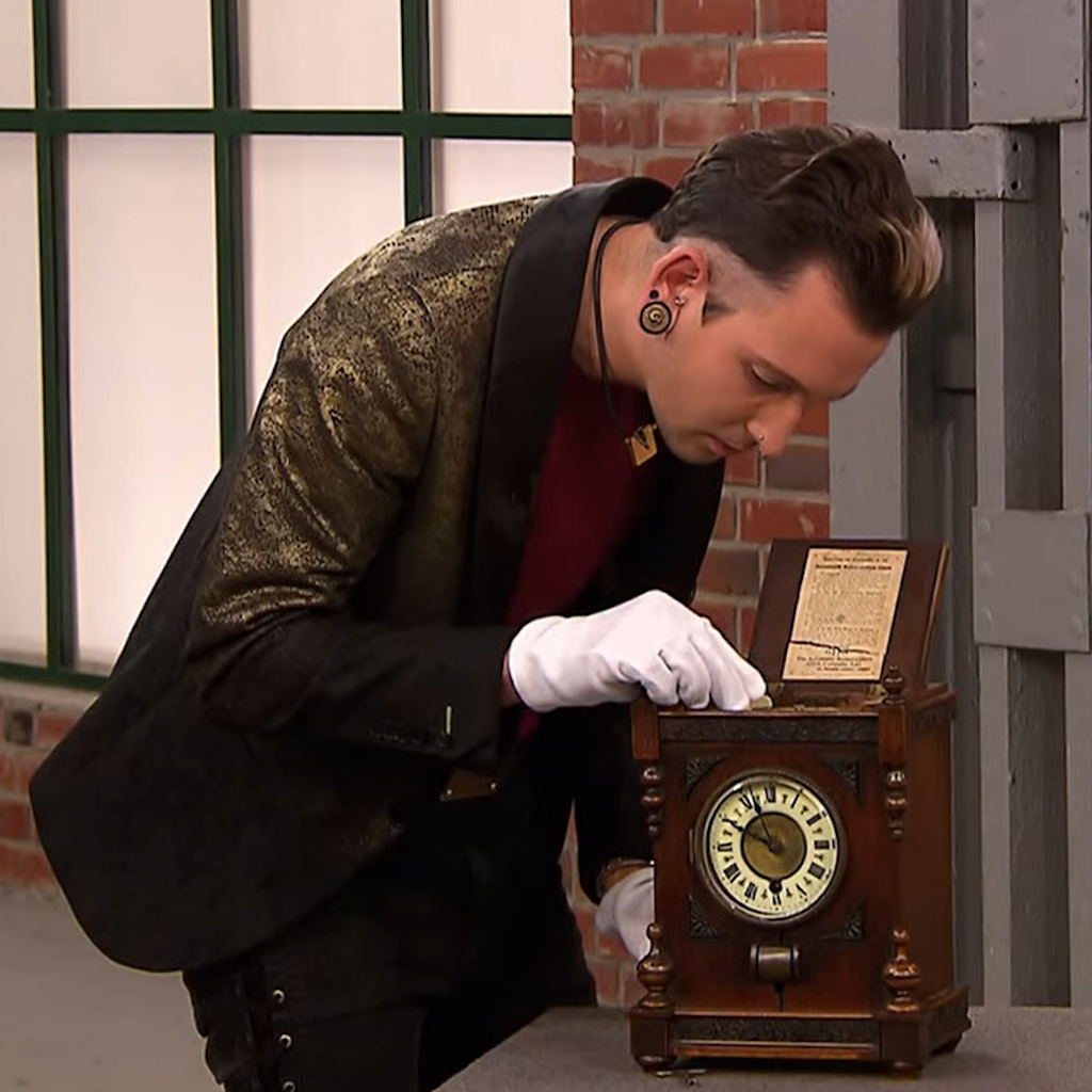Händler Fabian Kahl untersucht im Händlerraum bei „Bares für Rares“ die seltene Uhr.