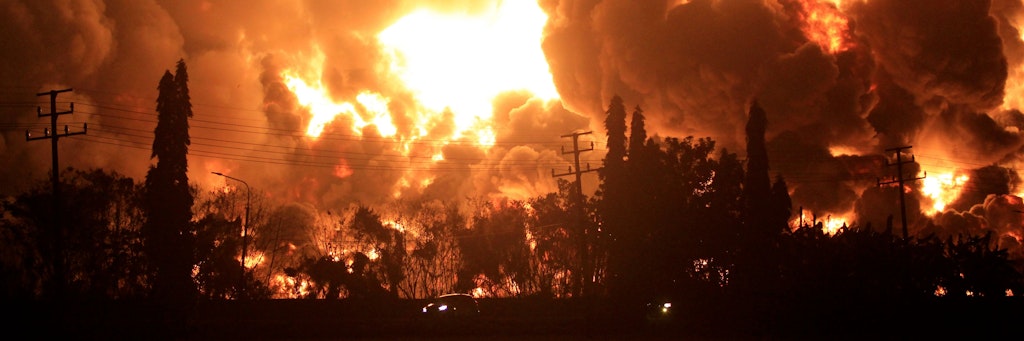Autos fahren auf einer Straße während eines Großfeuers in der Pertamina Balongan Raffinerie in Indramayu in Indonesien. 