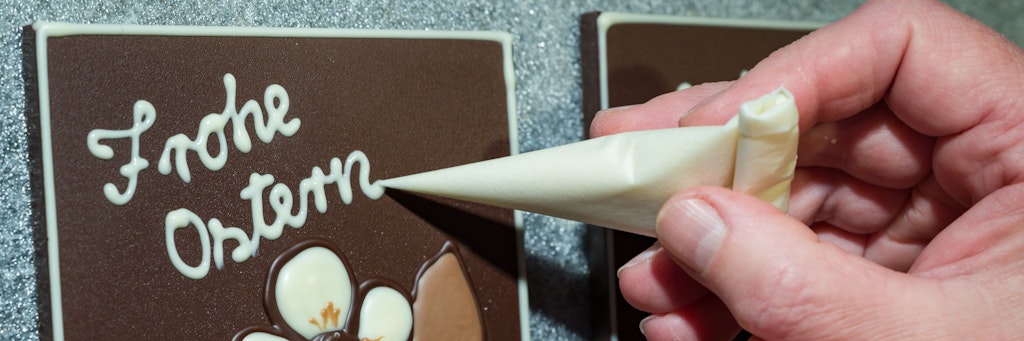 Schokoladentafeln werden werden in der Confiserie Felicitas für Ostern verziert.