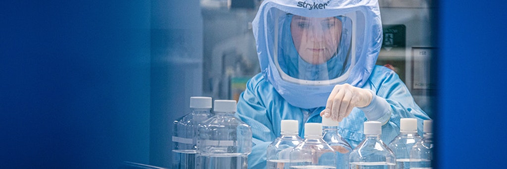 Mit Ganzkörper-Schutzanzügen simulieren Laborantinnen der Firma Biontech in einem Reinraum am neuen Produktionsstandort in Marburg die finalen Arbeitsschritte zur Herstellung des Corona-Impfstoffes an einem Bioreaktor.