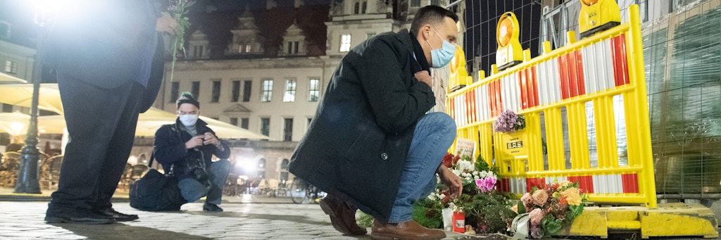 Viktor Vincze (r.), Vertreter Integrations- und Ausländerbeirat der Landeshauptstadt Dresden, legt am Tatort einen Kranz nieder.