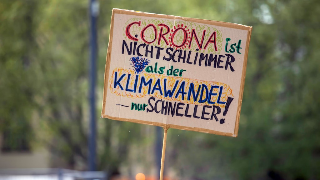 Fridays-for-Future-Demonstranten halten ein Plakat gegen den Klimawandel hoch.
