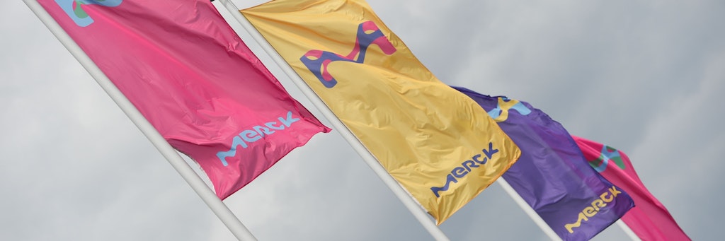 Fahnen mit dem Logo des Pharmakonzerns Merck.