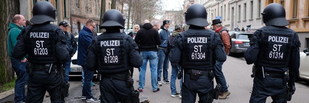 Teilnehmer einer Demonstration von Kritikern der Corona-Politik werden von Polizisten aufgehalten.