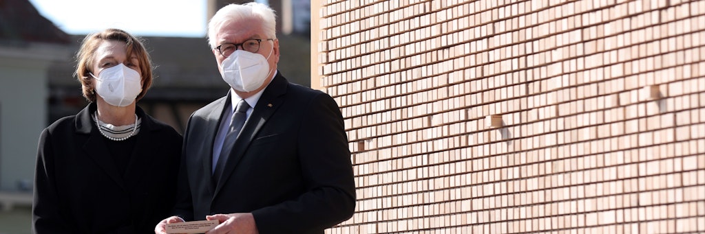 Bundespräsident Frank-Walter Steinmeier und seine Frau Elke Büdenbender vor der Installation „Verschwindende Wand“ mit Botschaften von KZ-Insassen.