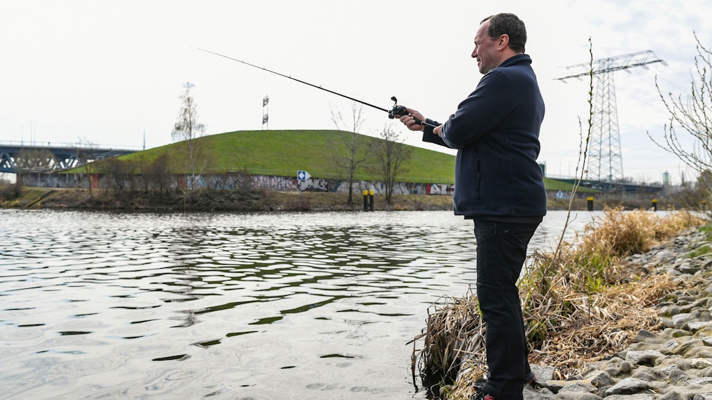 Ein Angler an der Spree. Deren Wasser wird durch eine unterirdische Wand gehindert, ins Grundwasser zu gelangen und Giftstoffe der alten Halde zum Wasserwerk Johannisthal zu transportieren.<br><br>