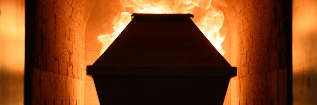 Ein Sarg fährt in einem Krematorium in den Einäscherungsofen.