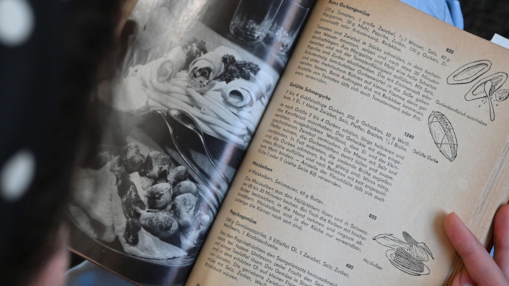 Ein Teenager blättert in dem Buch „Wir kochen gut“ aus den 60er Jahren. „Wir kochen gut“ gehört wie das „Kochbuch“ zu den auch als Reprint immer wieder neu aufgelegten DDR Kochbüchern.