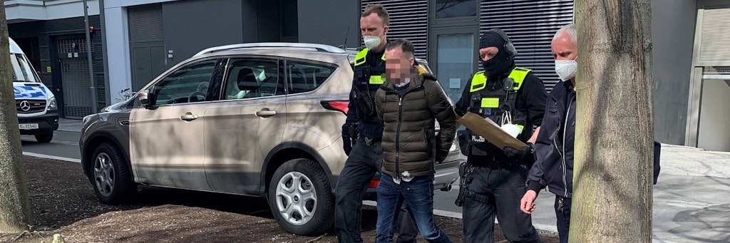 Einer der verhafteten Niederländer wird aus der Tiefgarage des Hauses geführt, in dem drei Wohnungen ausschließlich dem Umverpacken von Drogen dienten.