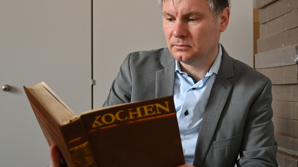 Sternekoch Jörg Frankenhäuser blättert in dem „Kochbuch“ vom Verlag der Frau aus den 70er Jahren. Das „Kochbuch“ gehört wie das Buch „Wir kochen gut“ zu den auch als Reprint immer wieder neu aufgelegten DDR Kochbüchern.
