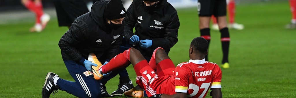 Ein Union-Spieler wird auf dem Rasen behandelt.