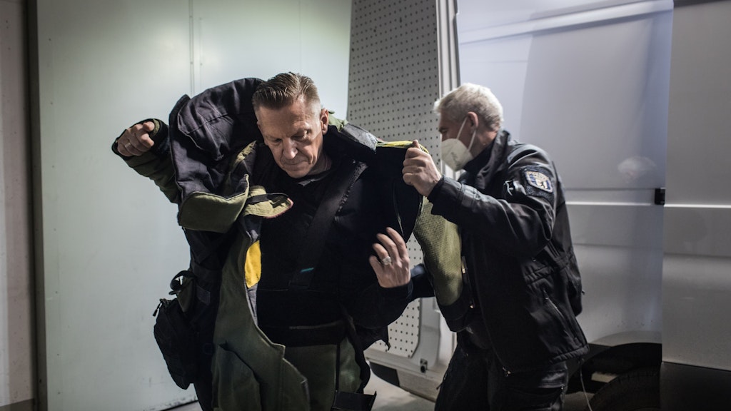 Mark Rehmer zieht sich den Bombenschutzanzug an. Das geht nicht allein. Ein Kollege hilft ihm dabei.
