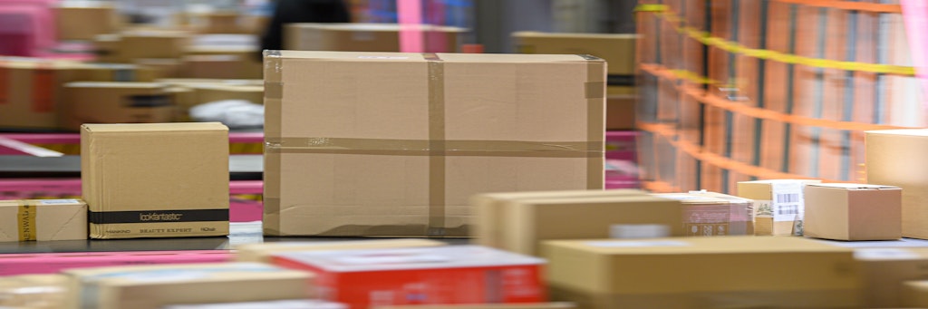 Pakete liegen im DHL-Paketzentrum auf einem Transportband