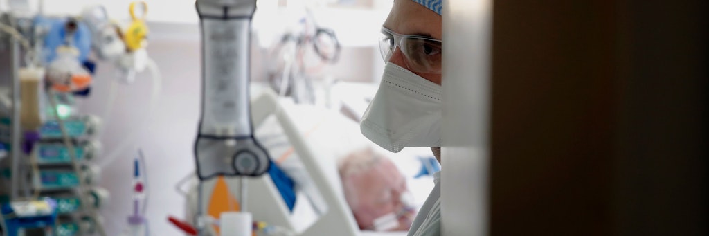 Ein Krankenhaus-Mitarbeiter überwacht die Beatmung eines Patienten über eine Maske. Die Methode wird in französischen Krankenhäusern einer Intubation möglichst vorgezogen.