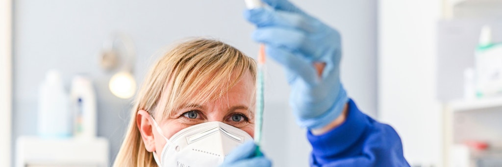 Eine Arzthelferin zieht für einen Patienten den Impfstoff auf. <br>
