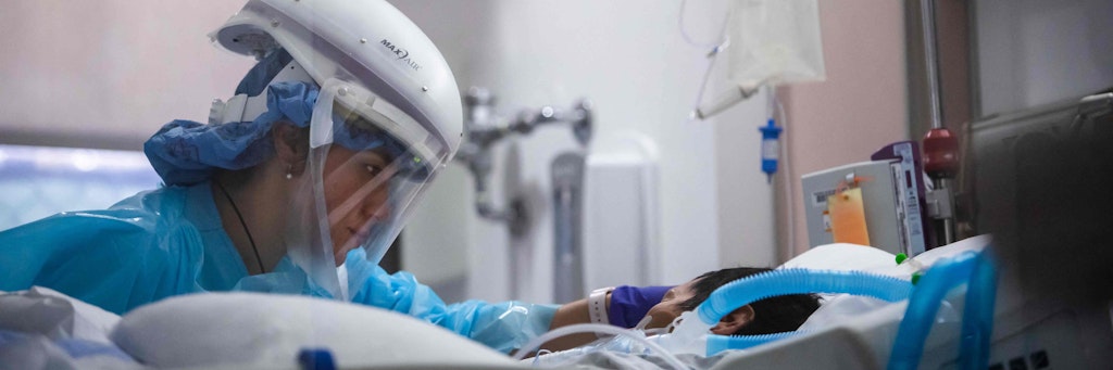 Eine Pflegekraft kümmert sich um einen Covid-Patienten.