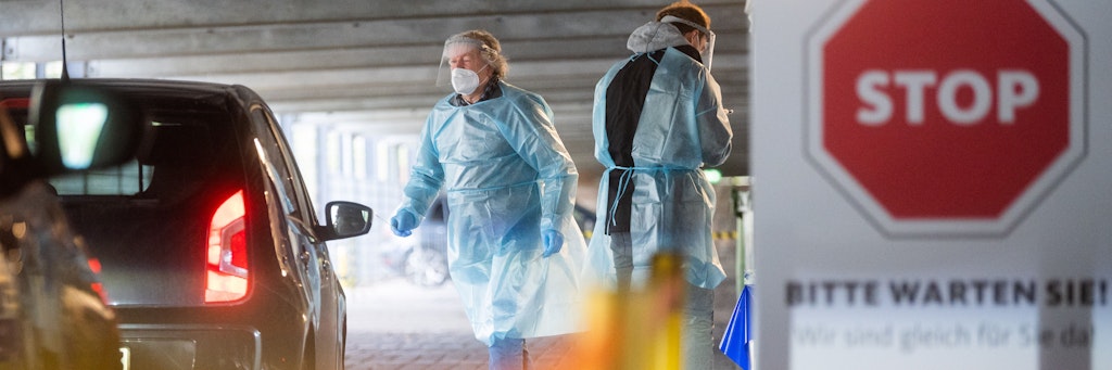 Helfer testen Insassen von Autos mit Schnelltests auf das neuartige Coronavirus. 