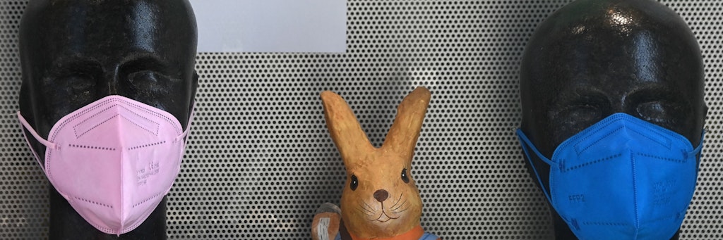 Ein Osterhase neben FFP2-Masken in der Auslage eines Geschäfts
