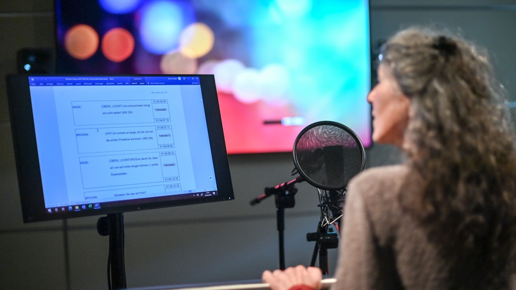 Schauspielerin Ulrike Johannson steht im Studio der Arena Synchron. Auf dem Teleprompter kann sie die zu sprechenden Sätze lesen. 