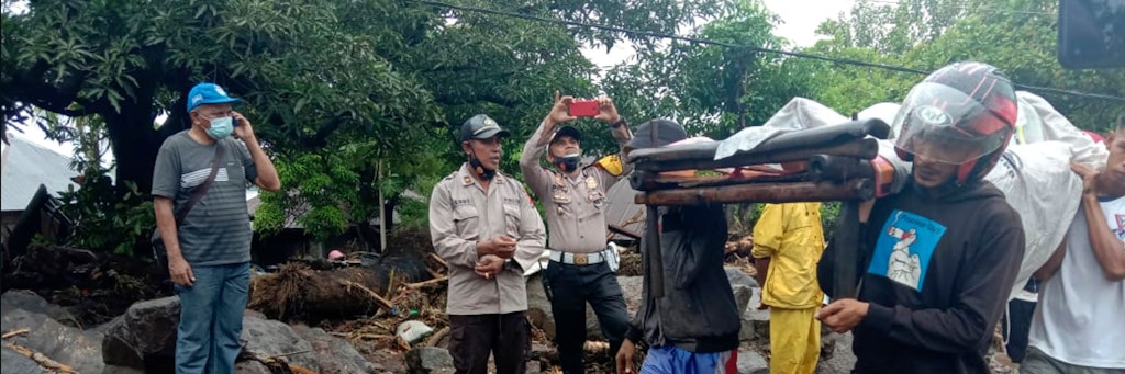 Ein bei den Sturzfluten in Indonesien verletzter Mann wird auf einer improvisierten Trage abtransportiert.