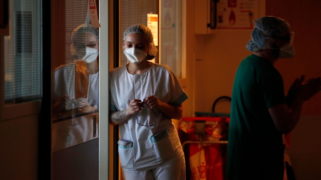 Erschöpft lehnt eine Krankenschwester in der großen Klinik von Amiens am Türrahmen. 