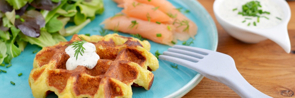 Der Kartoffelteig wird 5 bis 8 Minuten im Waffeleisen goldgelb zu Kartoffelwaffeln gebacken. Dazu passt Schnittlauch-Zitronen-Dip und Räucherlachs. 