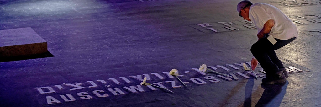 Ein Mann legt am Holocaus-Gedenktag in der Gedenkstätte Yad Vashem eine Blume ab. 
