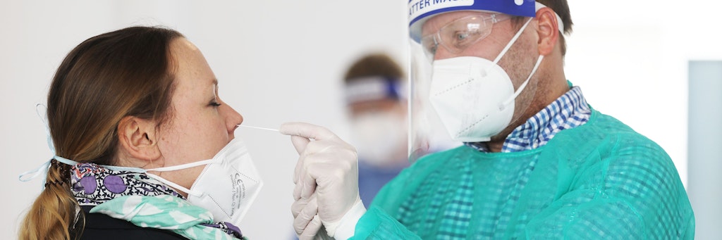 Ein Apotheker testet eine Frau in NRW auf Corona. Im Bundesland gelten ab Montag erste Erleichterungen für vollständig Geimpfte.