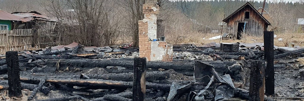 Nur noch Schutt, Asche und verkohlte Baumstämme: Die Reste des Holzhauses in der Stadt Kudymkar nach dem Brand. 