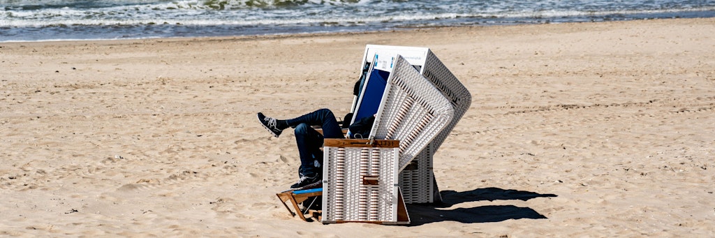 Ein Mann sitzt auf Sylt in einem Strandkorb.