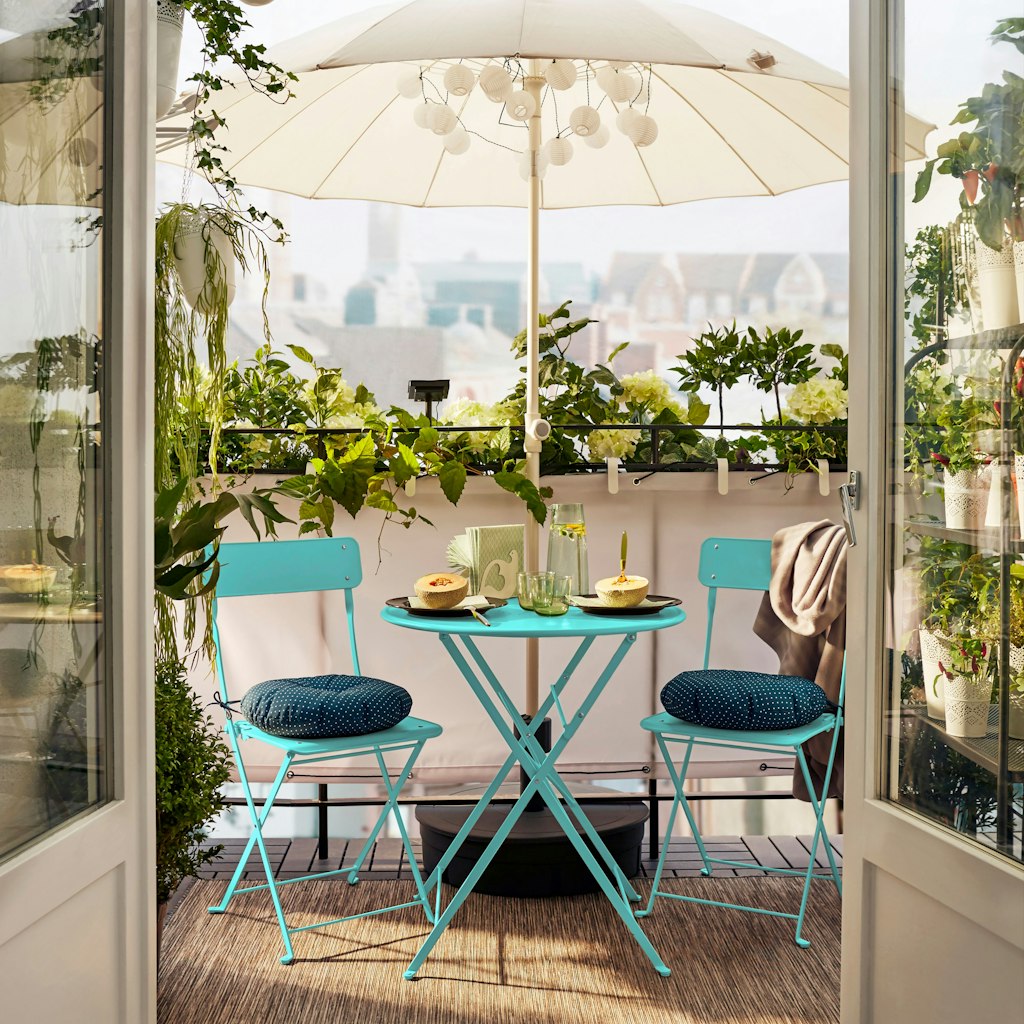 Ein Sonnenschirm spendet Schatten und sorgt auch an heißen Tagen dafür, dass der Balkon weiter nutzbar bleibt. 