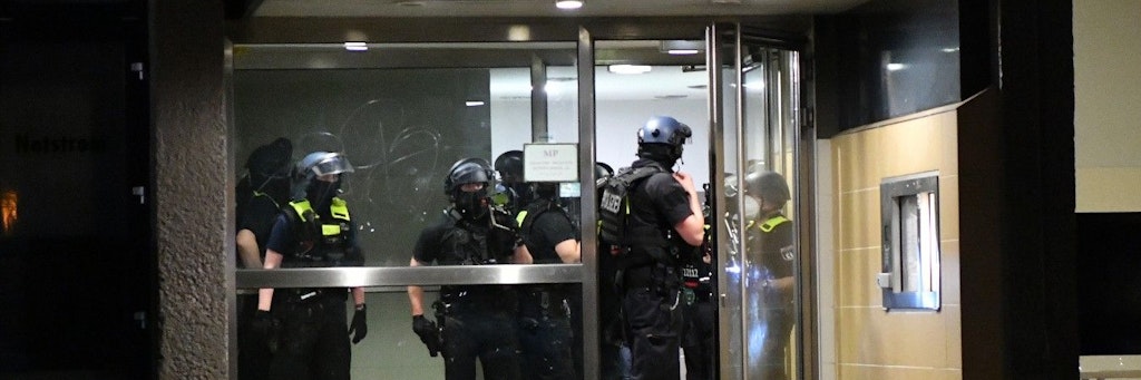 Polizeikräfte am Eingang des Hochhauses