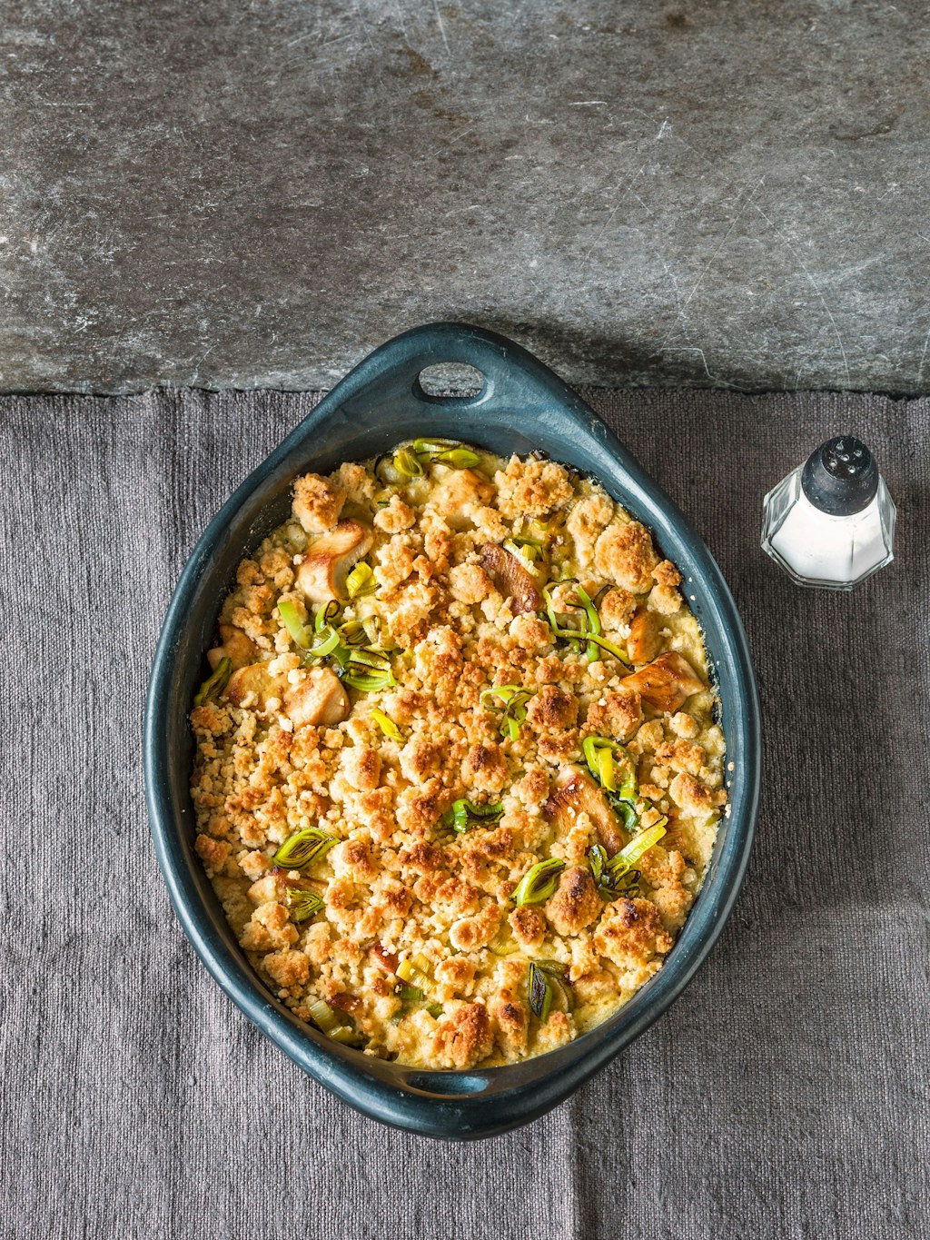 Die Kruste für den Hähnchen-Lauch-Auflauf ist mit Streuseln überbacken, die aus Mehl, Semmelbrösel, Butter, gehackten Haselnusskernen und Parmesan zubereitet werden.