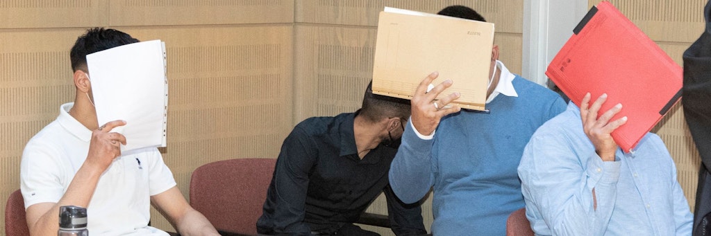 Vor Gericht versteckten sich die mutmaßlichen Räuber hinter Aktendeckeln.