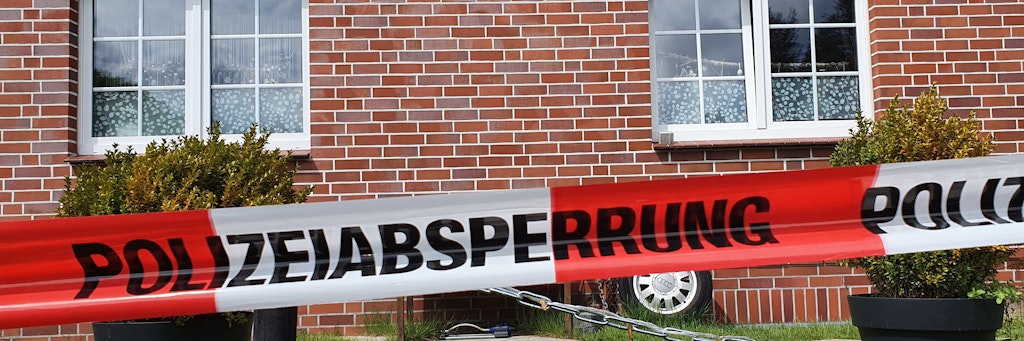 Ein Absperrband der Polizei hängt vor einem Haus in Bispingen. Darin wurden eine 35-jährige Frau und ihr vierjähriger Sohn tot aufgewunden. 