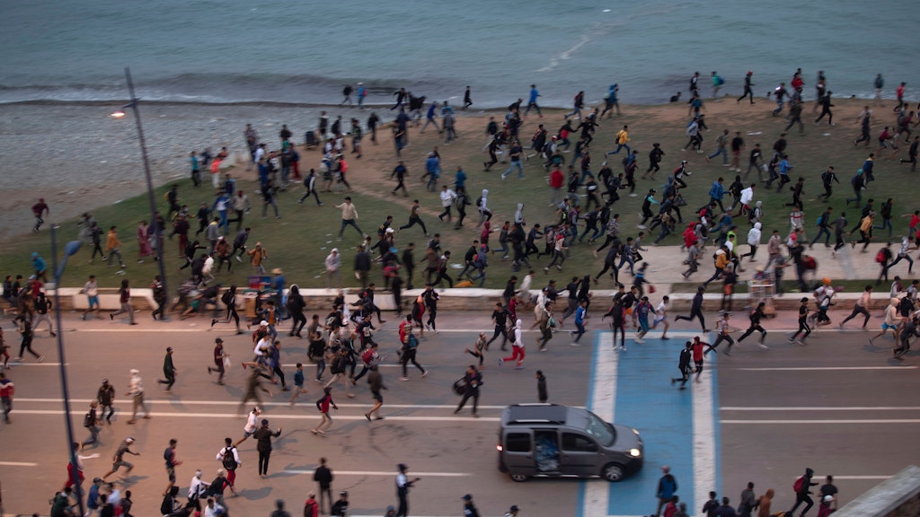 Marokkanische Jugendliche fliehen vor Sicherheitskräften, die sie daran hindern wollen, in die spanische Enklave Ceuta zu gelangen.