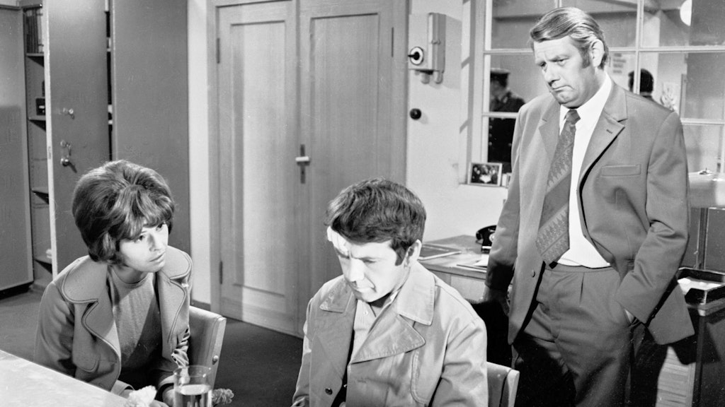 Der erste „Polizeiruf“, „Der Fall Lisa Murnau“, wurde am 27. Juni 1971 ausgestrahlt. Eine Postbeamtin und ihr Bekannter werden bei einem Postraub verletzt. Es gibt viele Verdächtige, die offensichtlich alle etwas zu verbergen haben. V.l.: Leutnant Vera Arndt (Sigrid Göhler), Harry Wolter (Ingolf Gorges) und Oberleutnant Peter Fuchs (Peter Borgelt).<br>