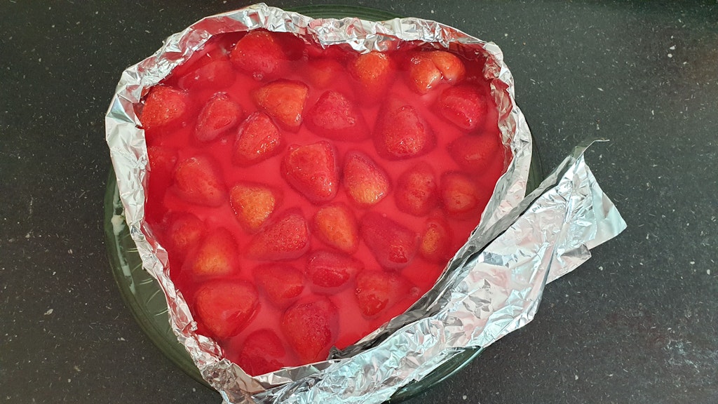 Mit Alu-Folie kann man den Rand erhöhen, damit Pudding und Tortenguss nicht vom Erdbeerkuchen laufen.