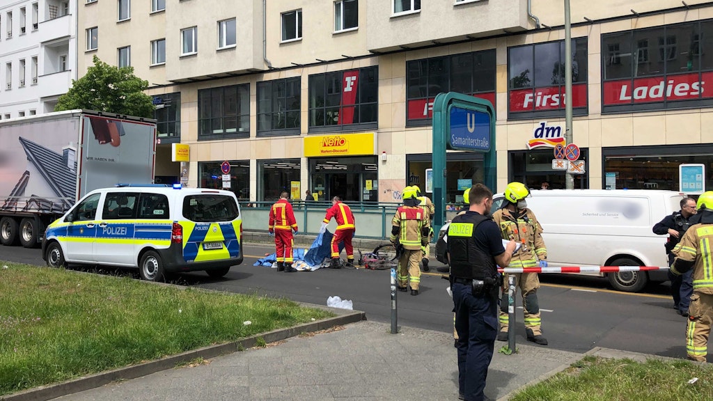 Mit Tüchern bedecken Rettungskräfte die Radfahrerin, die bei einem Unfall auf der Frankfurter Allee im Stadtteil Friedrichshain tödlich verletzt wurde.