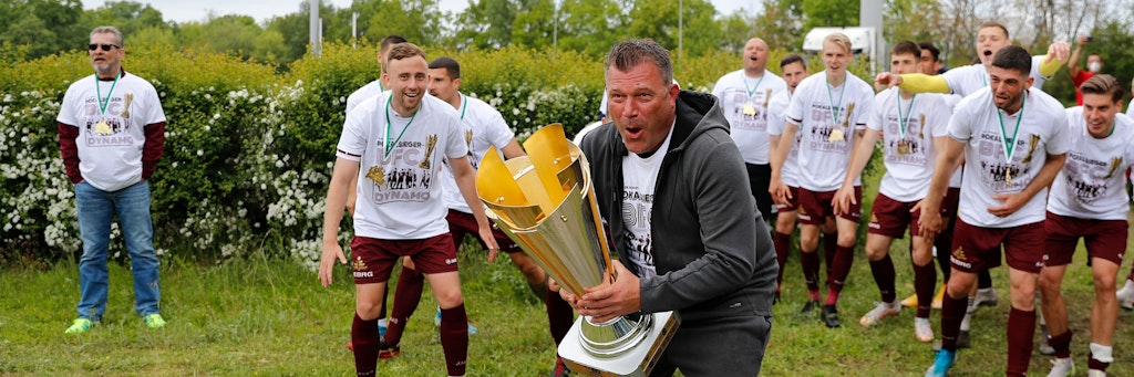 BFC-Trainer Christian Benbennek und seine Helden präsentieren den Pokal den vor dem Stadion wartenden Dynamo-Fans.