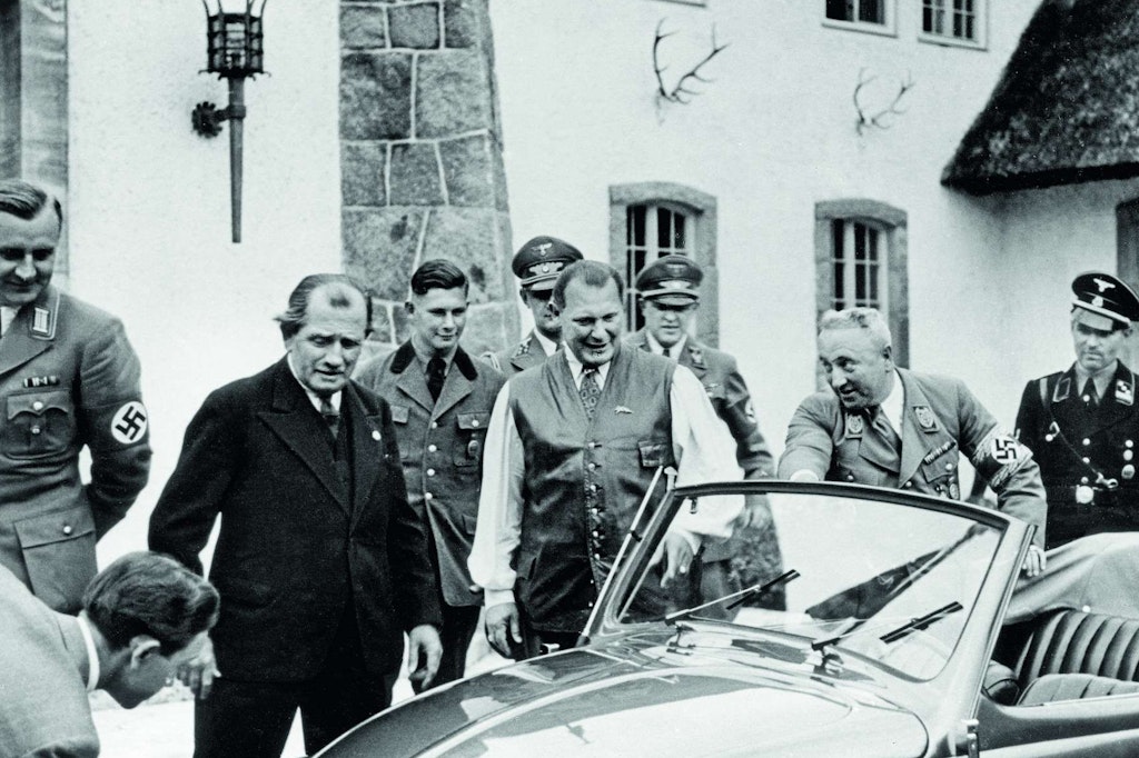 Auf Carinhall widmete sich Hermann Göring (Bildmitte) nicht nur der Jagd. Hier empfing er auch Größen aus Politik und Wirtschaft, wie Ferdinand Porsche (links, im Anzug), der ihm 1939 neuen KdF-Wagen mit Faltdach vorführte.
