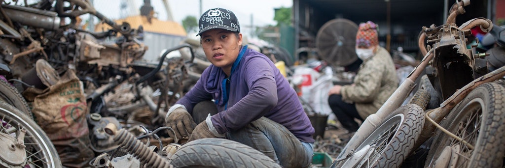 Arbeiterinnen zerlegen und sortieren ausgediente Motorräder in Tề Lỗ. Etwa 1000 Familien suchen hauptberuflich in rund 400 Recyclinghöfen nach wertvollem Altmetall zur Wiederverwendung und zum Verkauf.