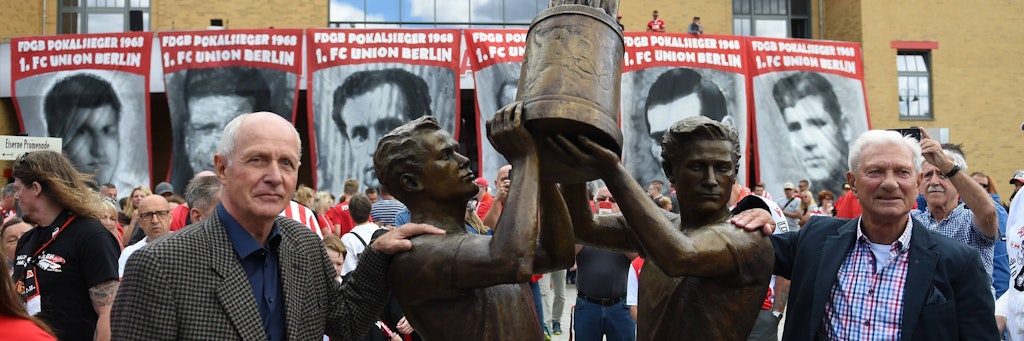 Ulrich Prüfke (l.) und Ralph Quest neben ihren Figuren des 68er-Pokalsieger-Denkmals. 