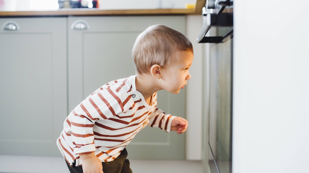 Toddler boy looking at oven in kitchen at home model released Symbolfoto property released PUBLICATIONxINxGERxSUIxAUTxHUNxONLY HAPF02833