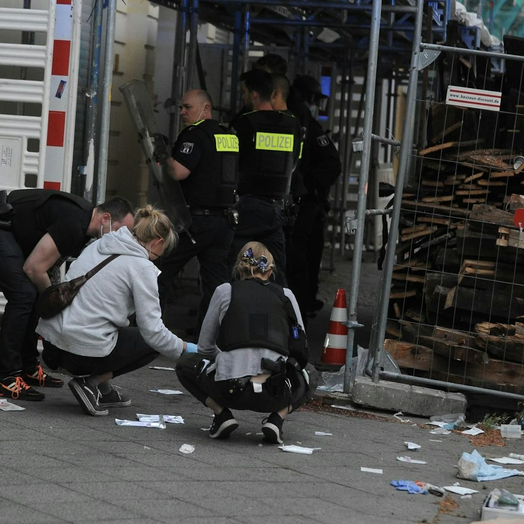 Polizeibeamte am Tatort, umgeben von Abfall der Notarzt-Behandlung.