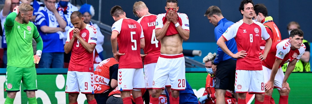 Dänemarks Spieler stehen geschockt um Eriksen, der auf dem Platz eine Herzattacke erlitt, herum. 