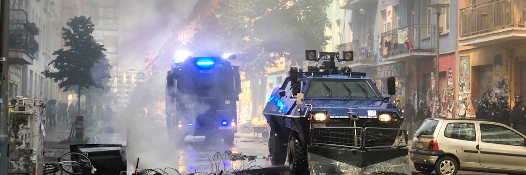 Räumpanzer und ein Wasserwerfer der Polizei fahren durch die Rigaer Straße in Berlin-Friedrichshain.