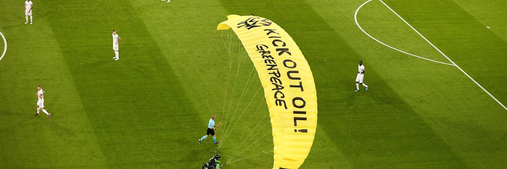 Ein Greenpeace-Aktivist landet auf dem Rasen der Münchner Arena.