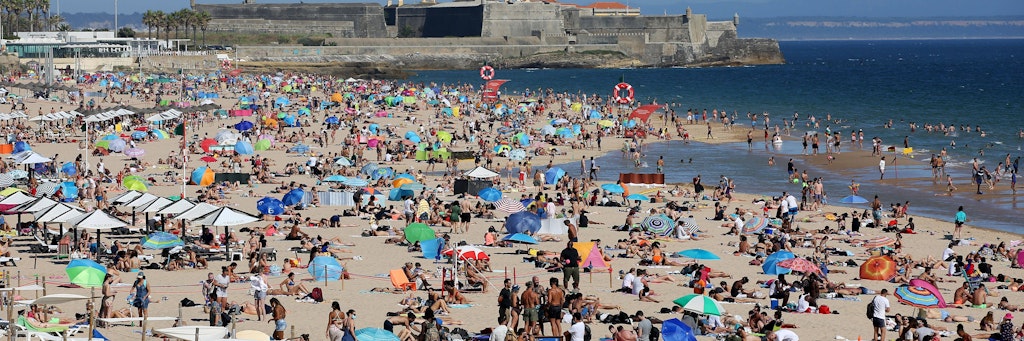 Einheimische und Urlauber genießen Sommer, Sonne und Meer an einem Strand nahe Lissabon. 