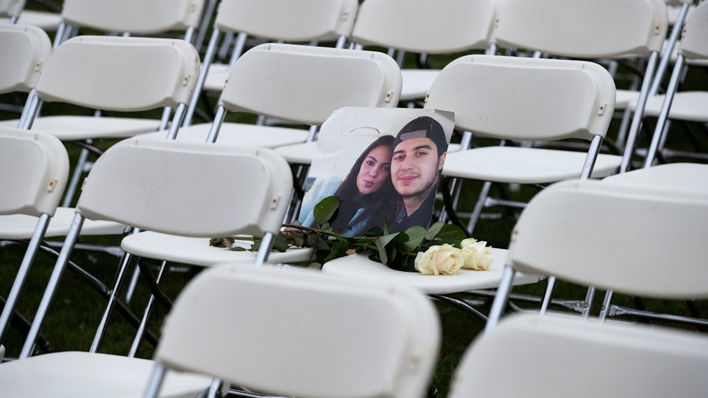 Ein Foto von Bryce Fredriksz und seiner Freundin Daisy lehnt zwischen zweien der 298 Stühle, die vor der russischen Botschaft in Den Haag aufgestellt wurden. Das Paar starb beim Abschuss von MH17.